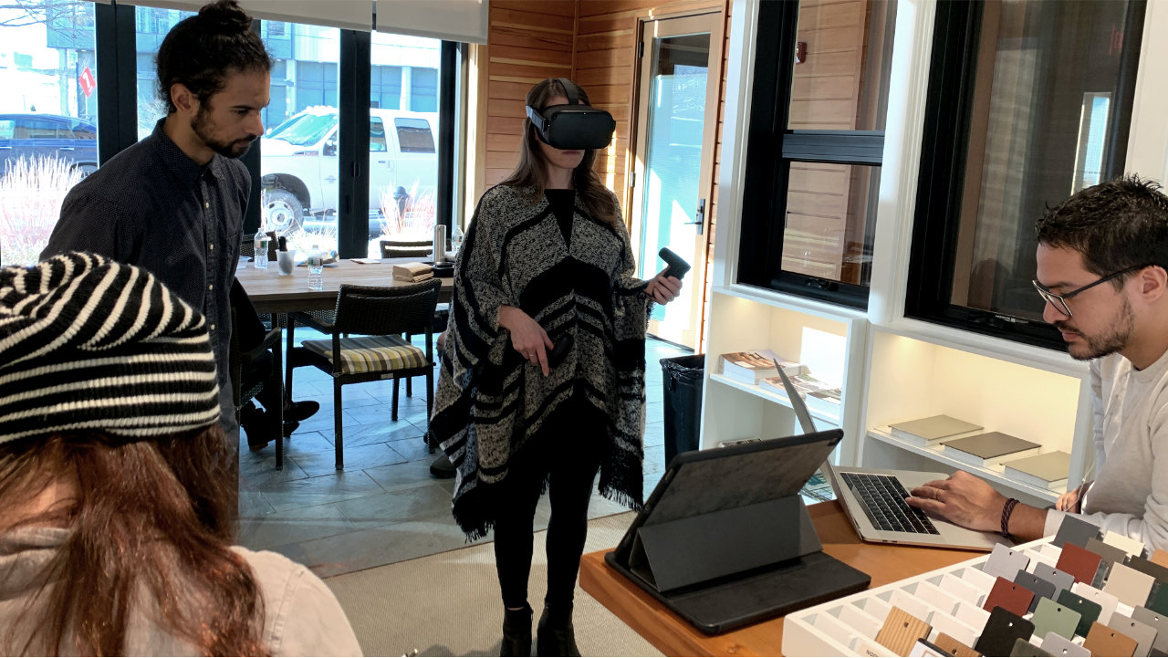 Colleagues observing a participant wearing a headset during a usability testing session