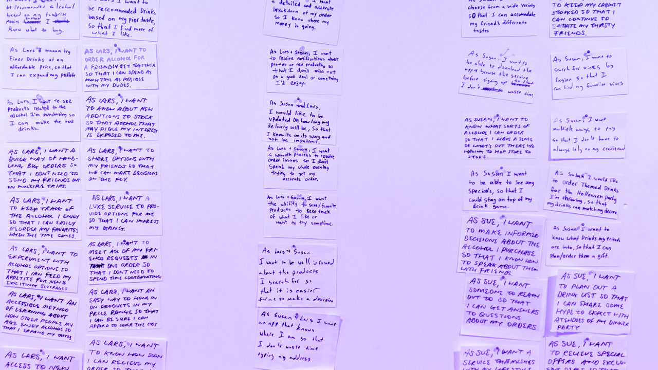 Variety of user stories are handwritten on index cards pinned to a large foamcore board.